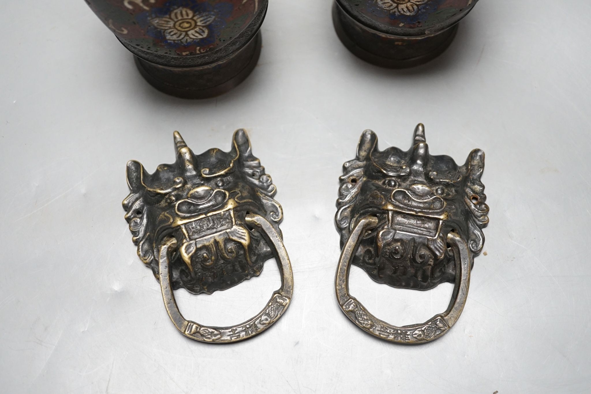 A pair of Chinese cast brass mask ring handles and a pair of Japanese enamelled bronze vases, 15 cm